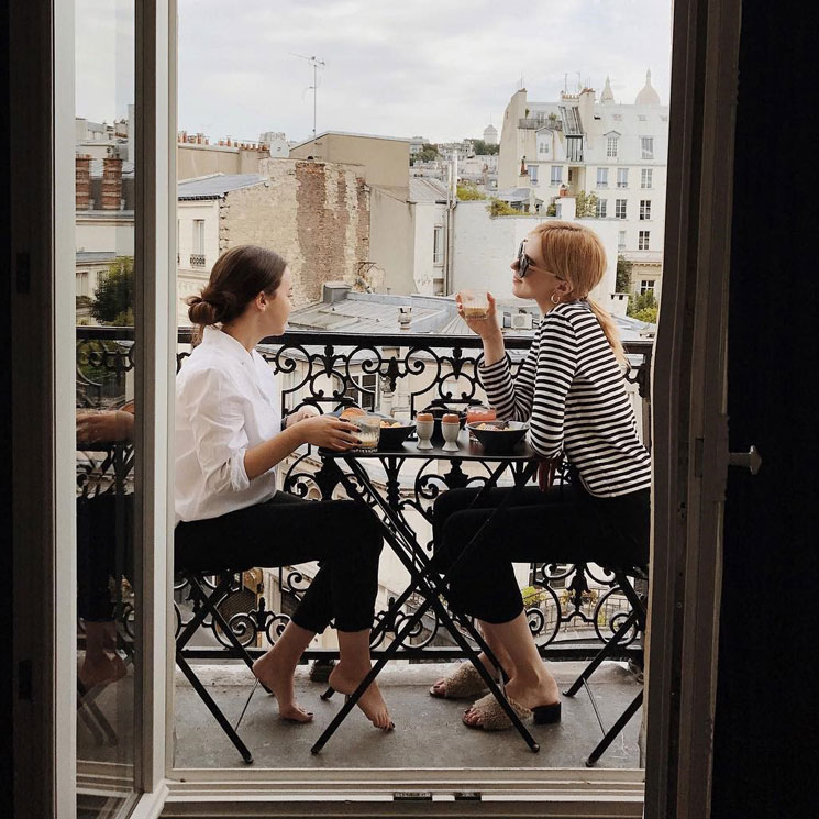 Chicas desayunando en el balcón