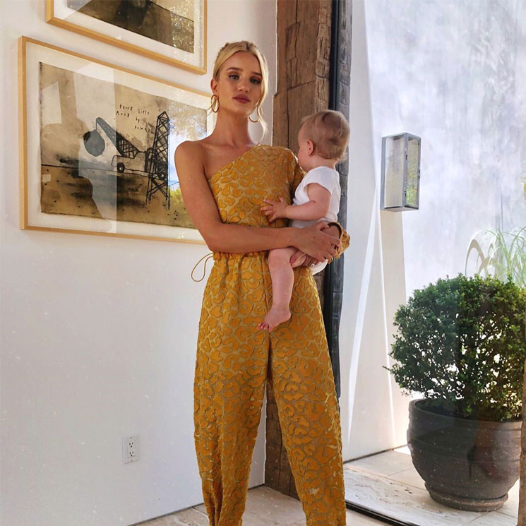 Rosie Huntington-Whiteley con mono amarillo y su bebé en brazos