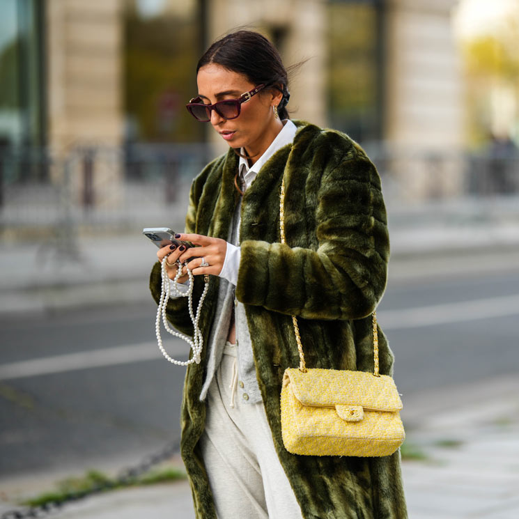 Gabriella Berdugo con abrigo de pelo verde, bolso amarillo y teléfono móvil